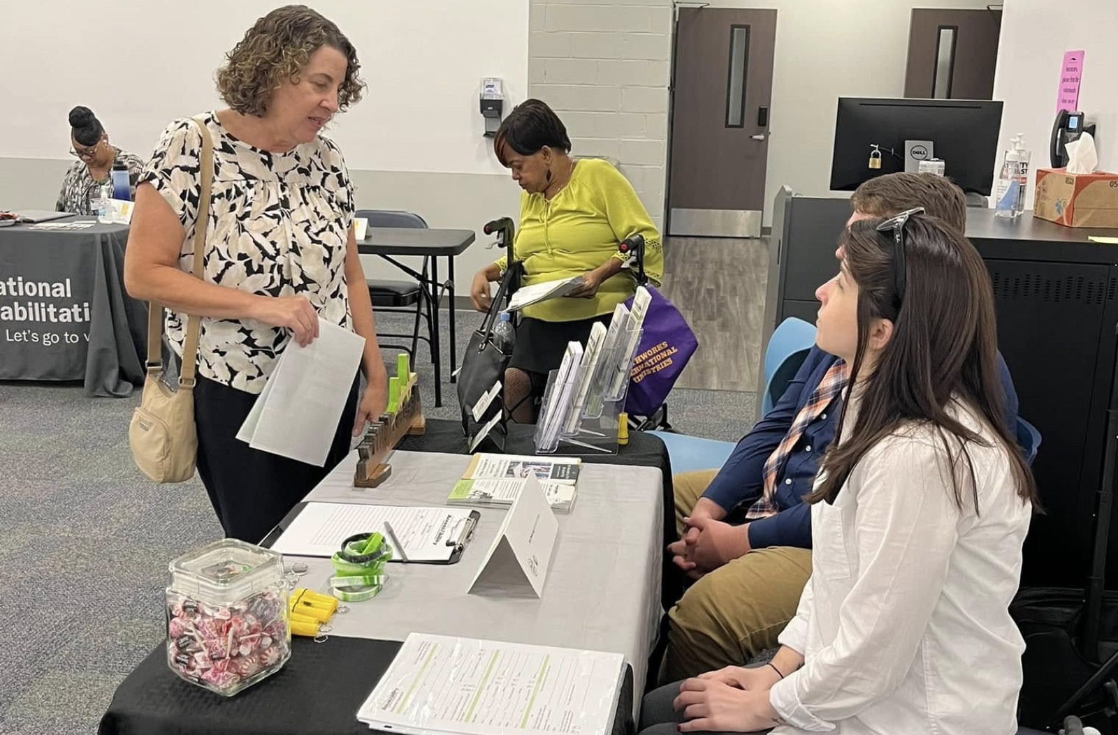 AccessAbility staff connecting with a community member at a resource-fair table.