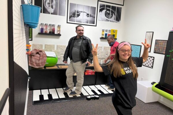 James and a LIT member in the music room at Scotty's Place having fun and using the foot piano.