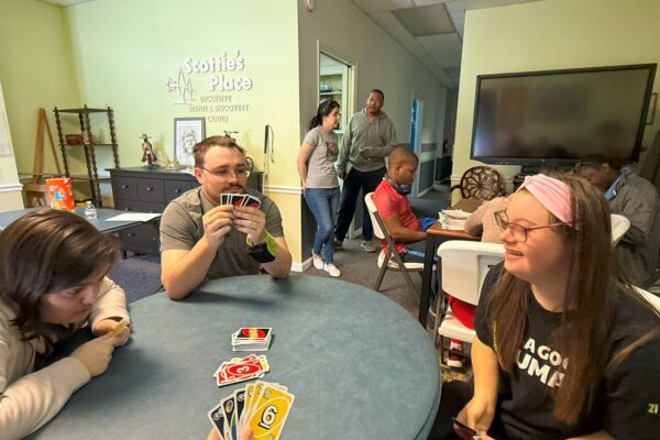 James from AccessAbility and two LIT members sitting at a table playing Uno.