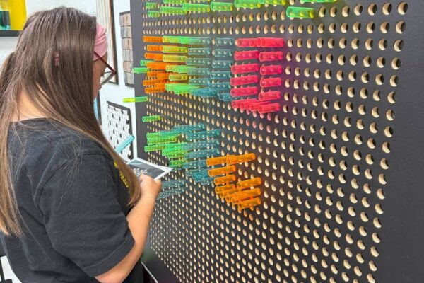 A LIT Member playing with the peg board in the music room at Scotty's Place.