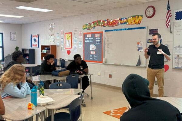 J from AccessAbility teaching in a classroom to a group of students.