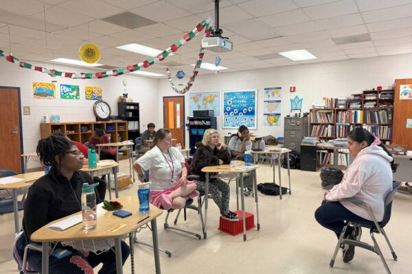 J from AccessAbility teaching in a classroom to a group of students.