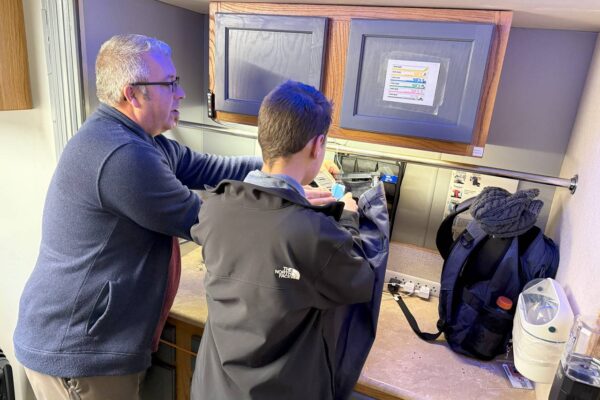 Tony from AccessAbility showing a student how to tag clothing on Big Benny.