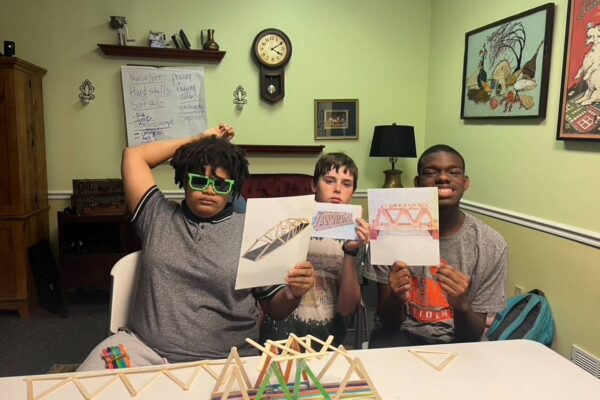 Summer session attendees posing for a group photos after successfully completing their team mini bridge challenge.